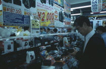 Shinjuku. Customers browsing in busy Camera shop interior
