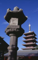 Asakusa. Senso Ji Temple. Angled view of the Five Storey Pagoda with ornamental stone column in the foreground