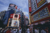 Shinjuku. View of advertisement covered architecture in busy city street scene