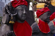 Row of Jizo statues dressed in red bibs by bereaved mothers and other sufferers