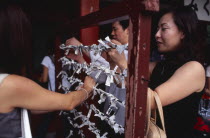 Asakusa. People tying Omikuji or Fortune papers at Senso Ji Temple