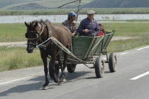 Traditional horse drawn cart carring people along the road