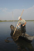 Professional fisherman in canoe on Lake Isac checking his nets