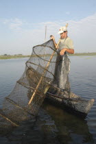 Professional fisherman in canoe on Lake Isac checking his nets
