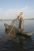 Professional fisherman in canoe on Lake Isac checking his nets