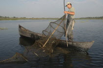 Professional fisherman in canoe on Lake Isac checking his nets