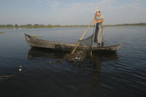 Professional fisherman in canoe on Lake Isac checking his nets