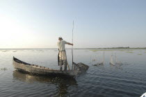 Professional fisherman in canoe on Lake Isac checking his nets