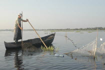 Professional fisherman in canoe on Lake Isac checking his nets