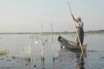 Professional fisherman in canoe on Lake Isac checking his nets