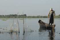 Professional fisherman in canoe on Lake Isac checking his nets