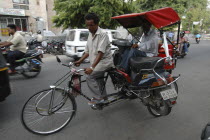 Cycle rickshaw transporting passenger and motorbike
