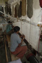 Boys weaving a Rajastan carpet on a large loom