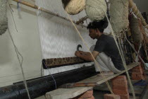 Man weaving a Rajastan carpet on a large loom