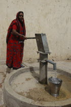 Woman filling bucket at Tara water pump