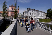 View along the Triple Bridge in the city centre with pedestrians crossing