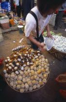 China, Yunnan, Kunming, Covered food market with baskets filled with thousand year old eggs.