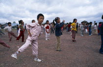China, Yunnan Province, Children taking in part in formation exercising outside of their school.
