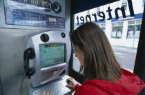 Communications, Phone Box, Young woman using a public BT Internet phone booth.