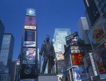 Times Square architecture and billboards with statue in the foreground