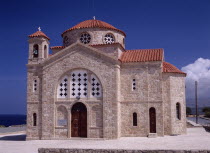 Exterior of church with red tiled roof and bell tower.