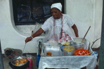 Woman cooking on street stall serving traditional slave food. Brasil