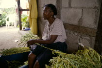Woman sitting sorting sesame seeds.
