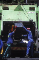 Municipal refuse collectors emptying waste bins into the truck
