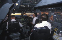South African Airways Boeing 747 300 cockpit with pilot and crew at daybreak over central Africa on a flight from London to Cape Town