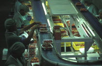 Female production line workers grading and packing strawberries at Mooiberg fruit and vegetable farm