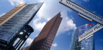 Angled view of the city skyscrapers and clock with a sign post for Potsdamer Platz and Stresemannstrass in the foreground