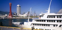 View over the port area with moored passenger ferry in the foreground and the Port Tower and city skyline behind