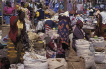 Market scene with female vendors selling grains and food products from sacks