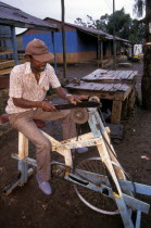 Man sharpening a knife on a pedal powered knife grinder