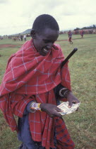 A Maasai man counts money from the sale of his cattle at a cattle market in Southern Kenya. Traditionally a Maasai mans wealth is measured by his number of cattle.