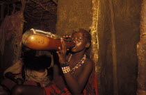 A Maasai Moran drinks traditional honey beer as part of his initiation ceremony into manhood. He will live inside the moran village for several months.