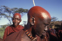 Maasai moran with their recently shaved heads covered with ochre which signifies their coming into manhood during an initiation ceremony of their age sets
