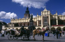 Horse drawn cart standing in the Market Square or Rynek Glowny with the facade of Drapers Hall behind