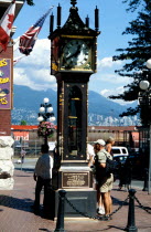 The Gastown Steam Clock with people reading the inscriptions around the base