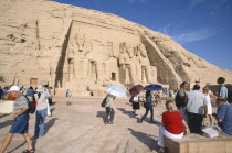 Sun Temple of Ramses II.  Tourists outside entrance flanked by four colossi of Ramses II.