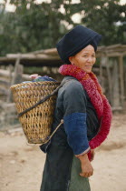 Yao tribeswoman carrying basket on her back.