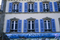 Douarnenez. Blue shuttered windows over Poissonnerie sign.
