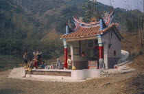 Colourful ancestors shrine with children sitting in front
