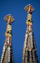 La Sagrada Familia unfinished church designed by Gaudi.  Detail of two spires topped with Venetian mosaic.