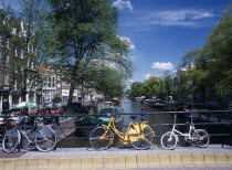 Bicycles leaning against the railings of a bridge over the Prinsengracht canal