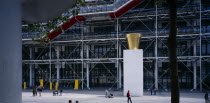 Pompidou Centre.  Exterior of building by Renzo Piano and Richard Rogers.  Sculpture and people in plaza area in front of entrance.