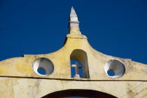 City gateway  architectural detail with cross in arched window.