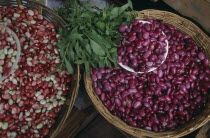 Pink  white and red shelled beans displayed in shallow baskets.