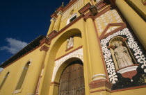 Catedral de San Cristobal.  Sixteenth century cathedral painted in brown  white and yellow. Part view of exterior wall with statue set into niche surrounded by plant motif.  Cathedral