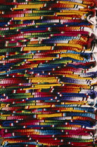 Close view of layered pile of multicoloured textiles.    Multi-coloured Multicolored